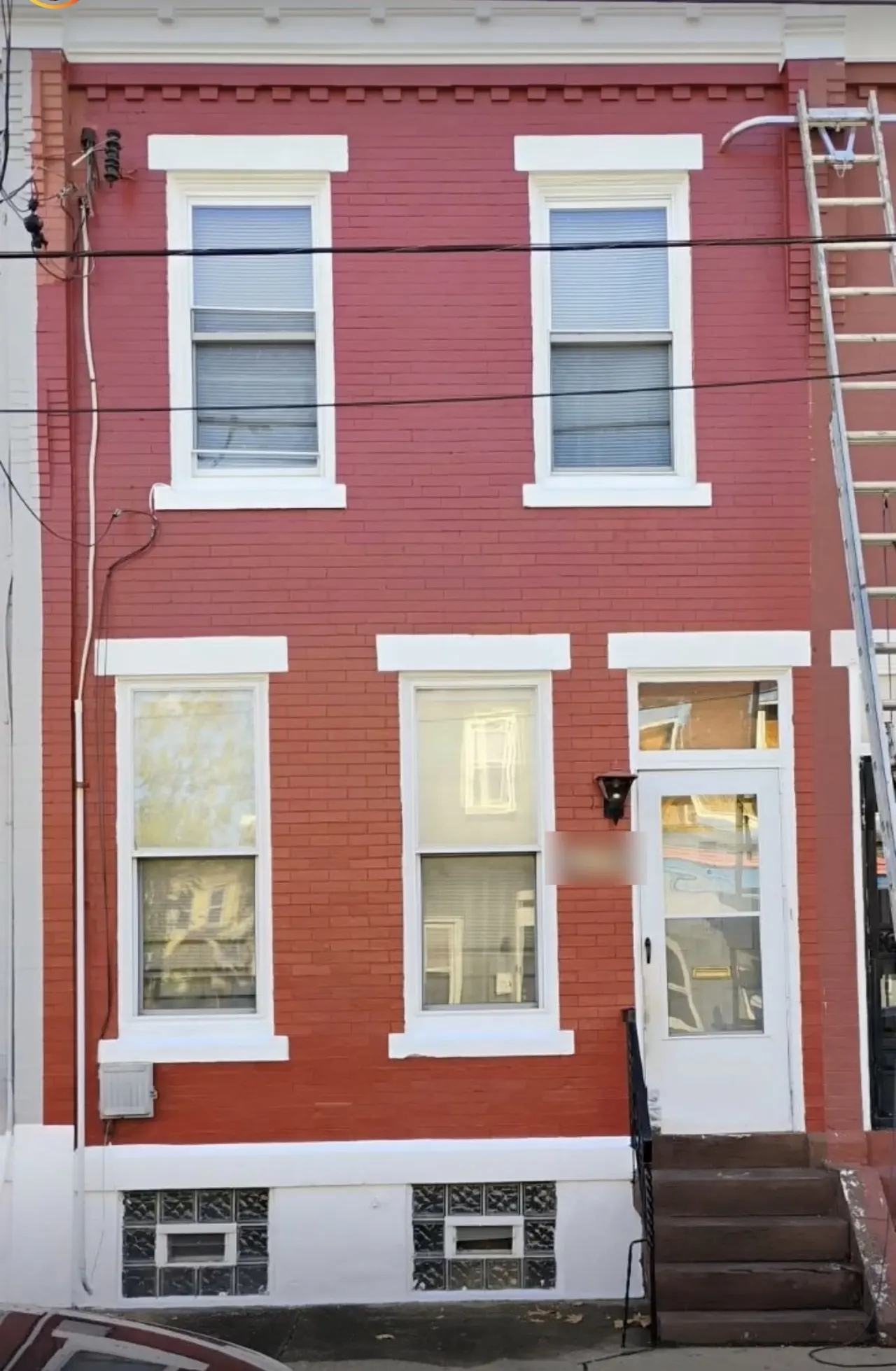Freshly painted red brick row home with crisp white trim